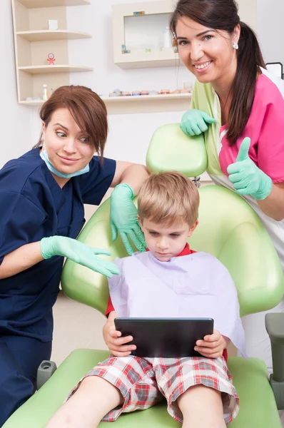 Modern dental team offering entertainment for kid patient
