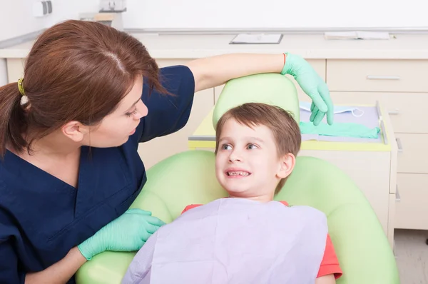 Smiling kid in dentist office with friendly woman doctor