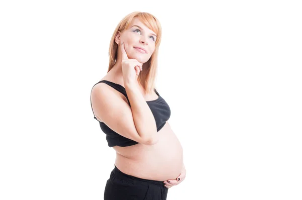 Beautiful pregnant woman thinking wondering or day-dreaming with