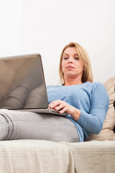 Woman sitting on the couch with laptop on lap