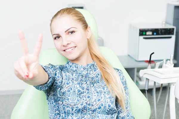 Relaxed female patient showing peace or victory gesture