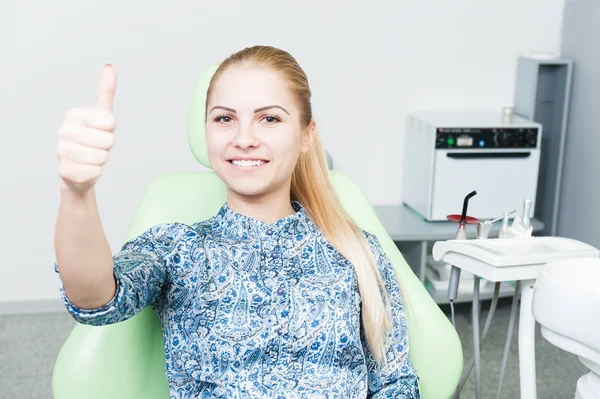 Relaxed female patient showing like on dentist chair