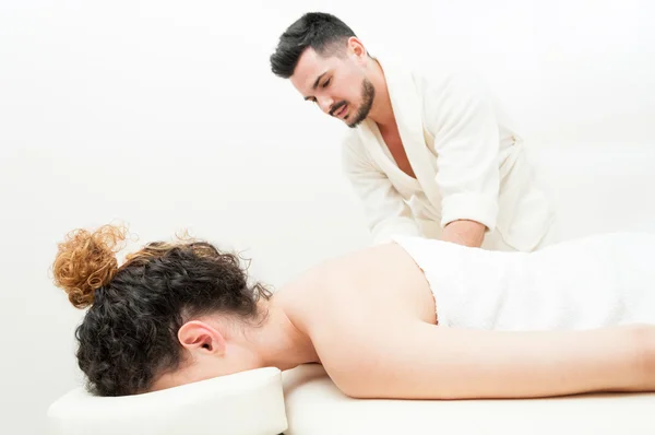 Young female is getting a body massage by handsome man