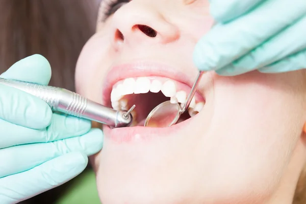 Mouth with drilling tool and mirror at dentist