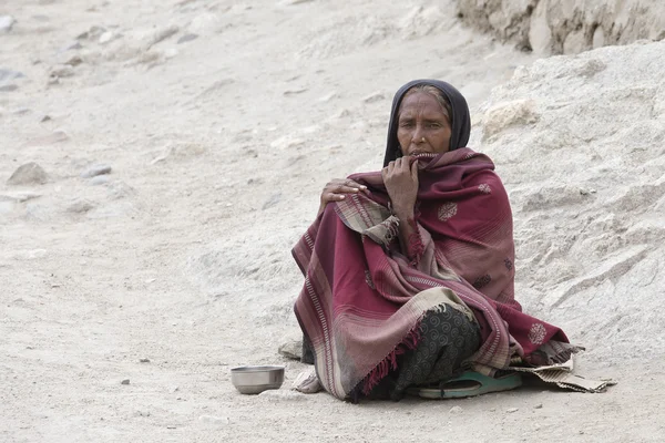 Poor woman begs for money from a passerby on the street in Leh, Ladakh. India
