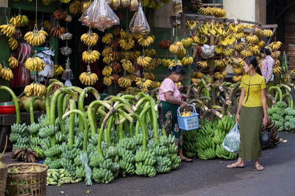 Burmans people buy and sell bananas on the street food market in the city center. Yangon, Myanmar