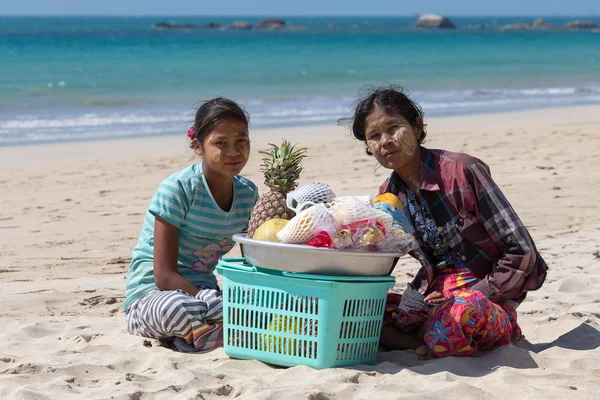 Burmese women selling fresh fruits at the shoreline to tourists in Ngapali beach. Myanmar