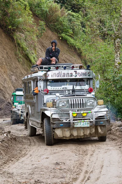 Local public transport jeepney driving fast along a dirt road in the mountain province of banaue in northern luzon in the philippines