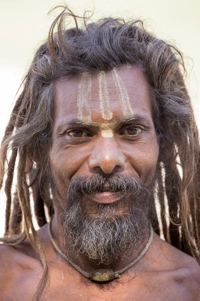 Sadhu, holy man sits on the ghat along the Ganges river. Rishikesh, India