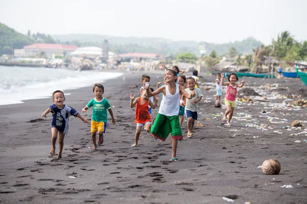 Children group on the beach with volcanic sand near Mayon volcano, Philippines