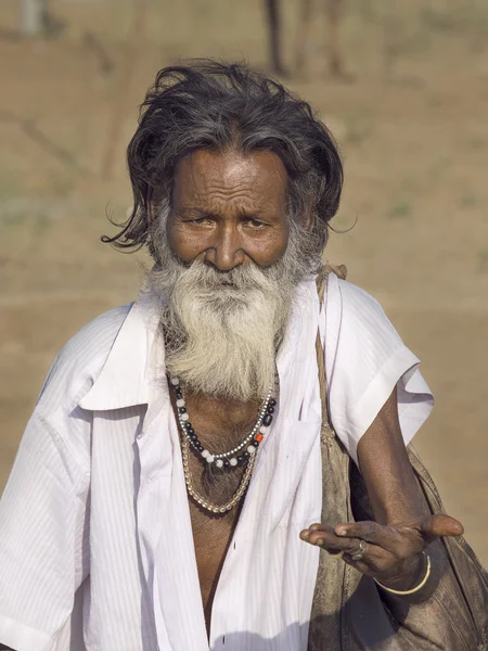 Old indian beggar waits for alms on a street. Pushkar, India