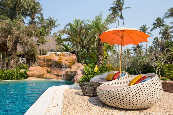 Swimming pool and beach chairs in a tropical garden, Thailand