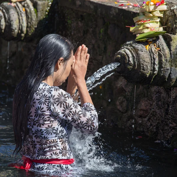 Balinese families come to the sacred springs water temple of Tirta Empul in Bali, Indonesia to pray and cleanse their soul