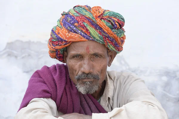 Indian man on the ghat along the sacred Sarovar lake in Pushkar, India