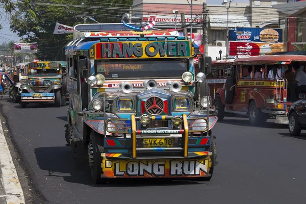 Jeepneys passing, Filipino inexpensive bus service. Jeepneys are the most popular means of public transportation in the Philippines.