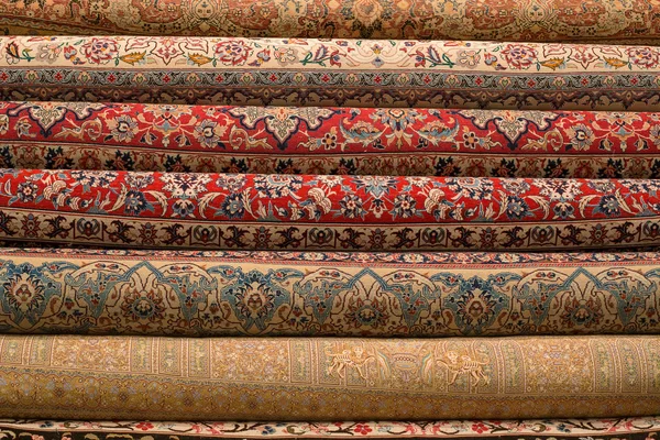 Rolled-up turkish or persian carpets in a variety of colors in a carpet store