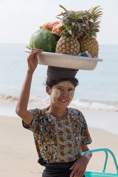 Burmese woman selling fresh fruits at the shoreline to tourists in Ngapali beach. Myanmar