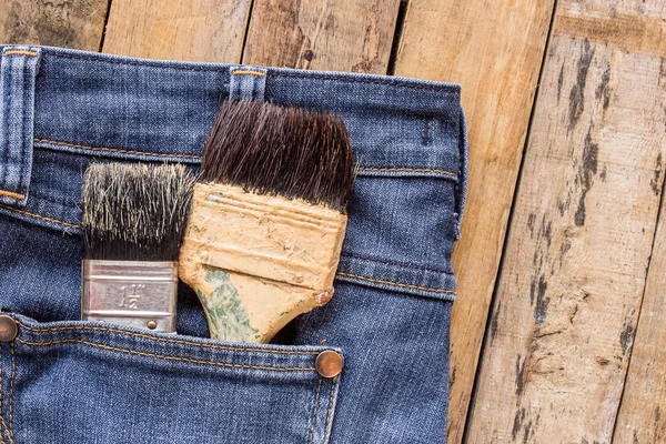 Two paint brushes in jeans pocket