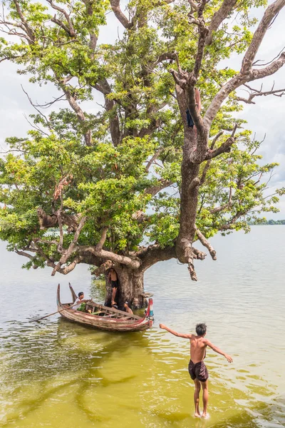 Myanmar children were playing by jumping from the tree at the river near U Bein Bridge