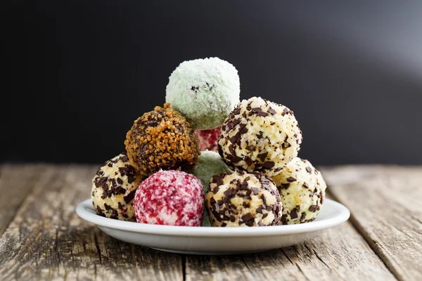 Delicious vegetarian truffle candies on wodden table.