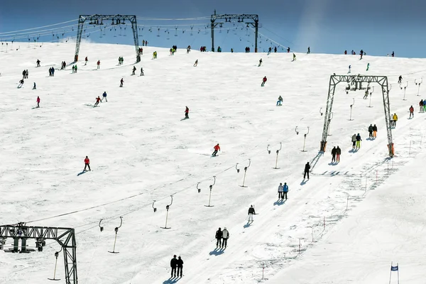 Skiing people, the chair lifts and rope tow systems of Zell am See ski region in Austria