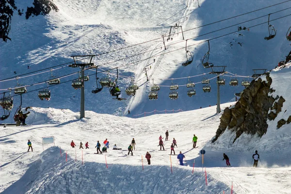 Skiing people, the chair lifts and rope tow systems of Zell am See ski region in Austria