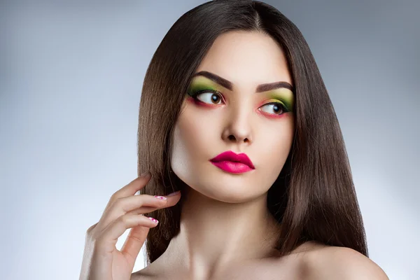 Fashion portrait of a young beautiful girl with bright makeup.