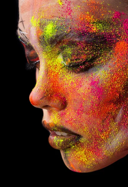 Beauty fashion portrait of a girl close-up. bright creative make-up. Face model sprinkled colored powder