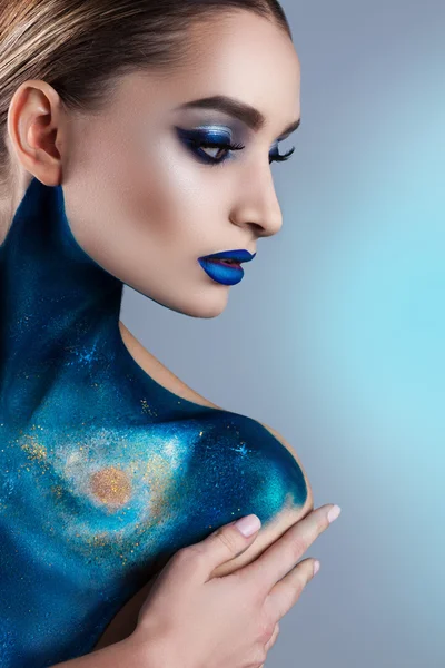 Beautiful girl with creative make-up . Bright colors blue lips.  Conceptual art  the cosmos, the universe
