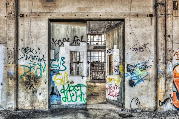 Large tagged door inside an abandoned factory