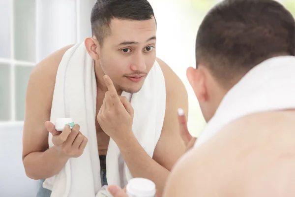 Man applying moisturizer cream