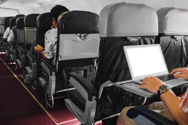 Man working on laptop in aircraft cabin