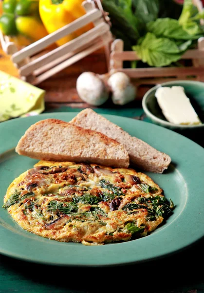 Spinach mushroom omelette served with toast and butter