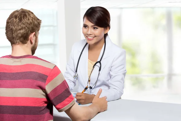 Smiling doctor giving a consultation to a patient in her medical