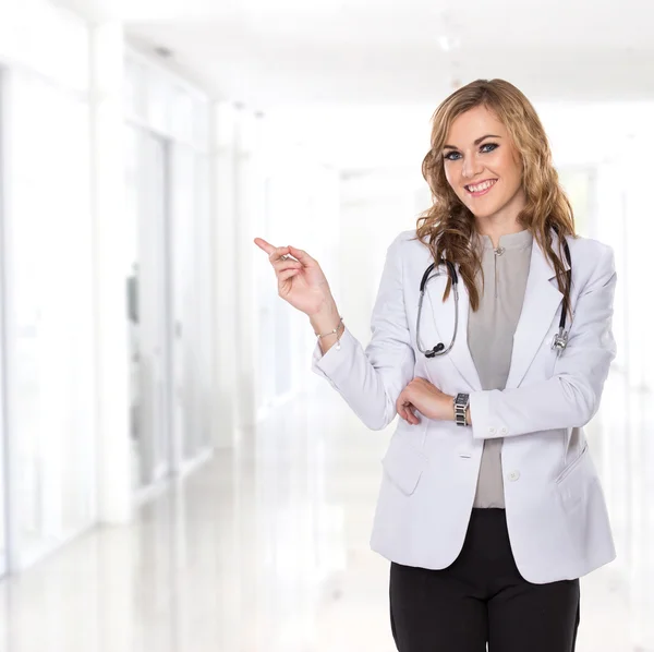 Young female doctor smiling showing blank copyspace