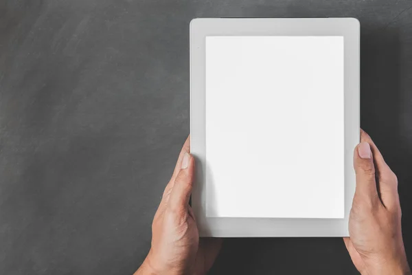 Hands holding tablet with white blank screen