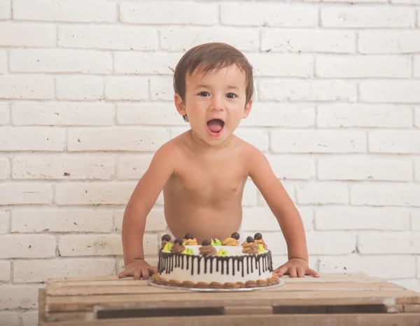 Cute caucasian boy scream in front of a cake