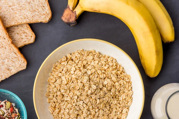Oatmeal in a bowl, banana, milk, and dry bread