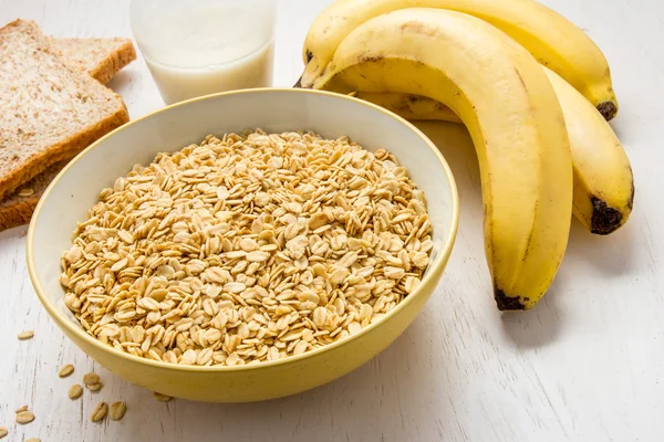 Healthy breakfast with oatmeal, banana, dry bread, and milk