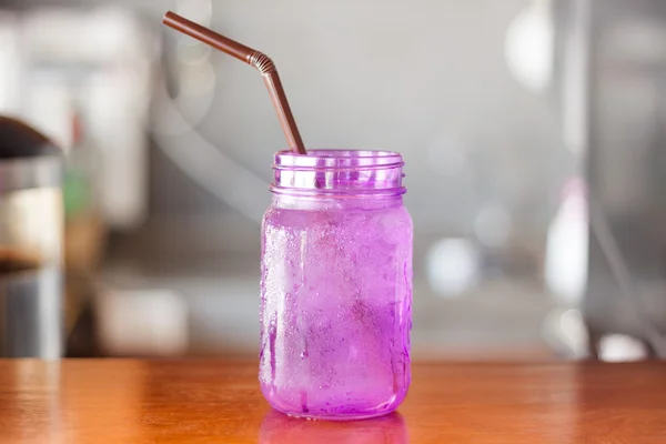 Iced drink in violet glass in coffee shop
