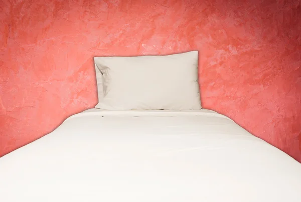 Close up white bedding and pillow on red wall background