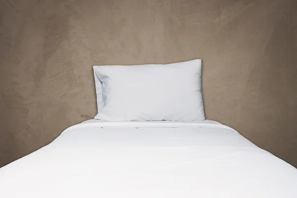 Close up white bedding and pillow on gray concrete background