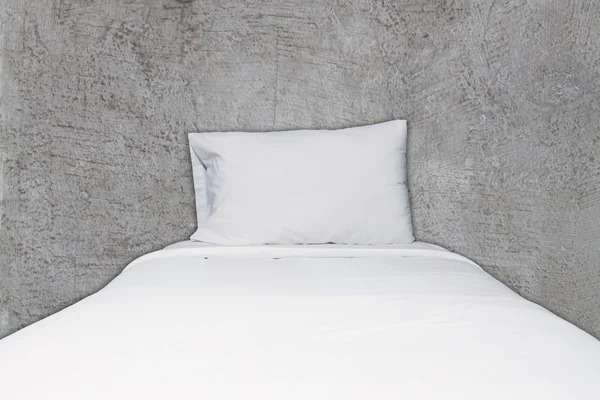 Close up white bedding and pillow on abstract gray concrete back