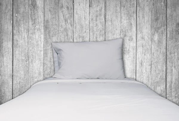 Close up white bedding and pillow on wooden background