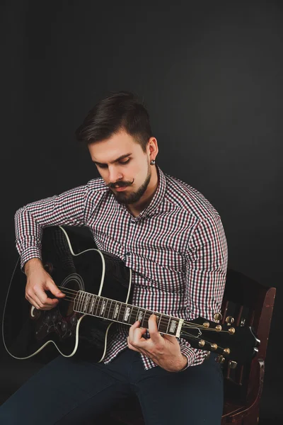 Handsome guy with beard holding acoustic guitar