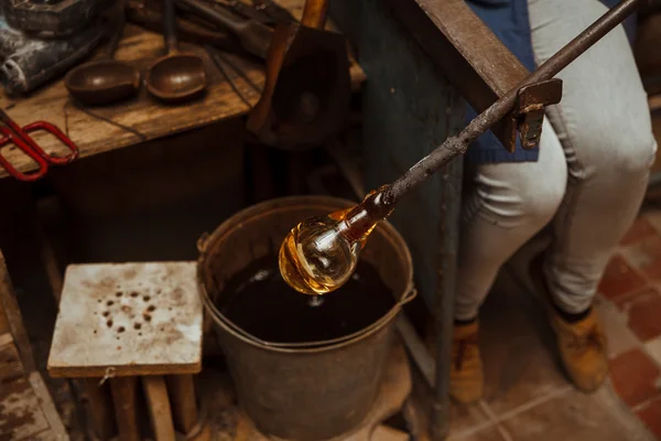 Glass Artist in her workshop making glassware