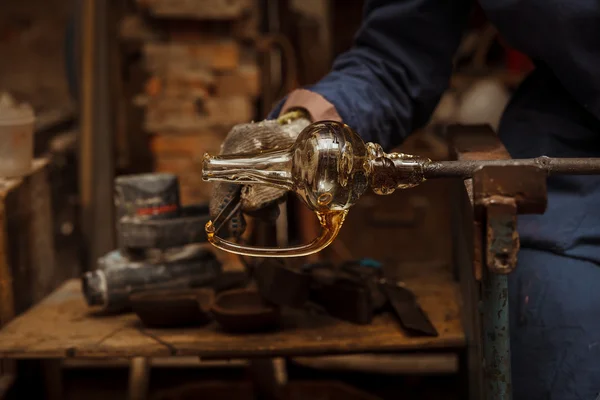 Glass Artist in her workshop making glassware