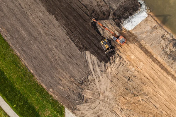 Aerial view of long arm excavator working on the field