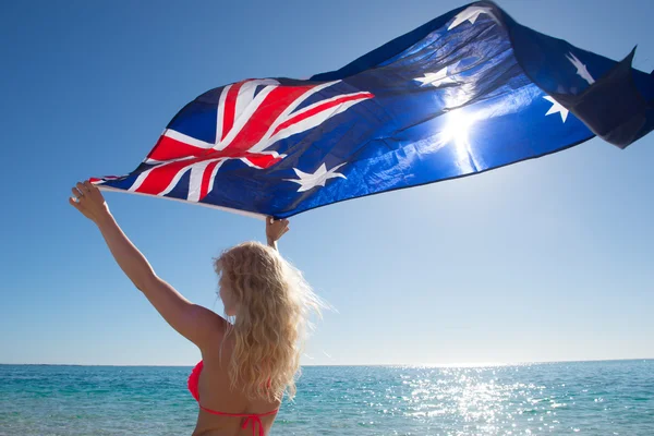 Blonde woman Australian flag at ocean