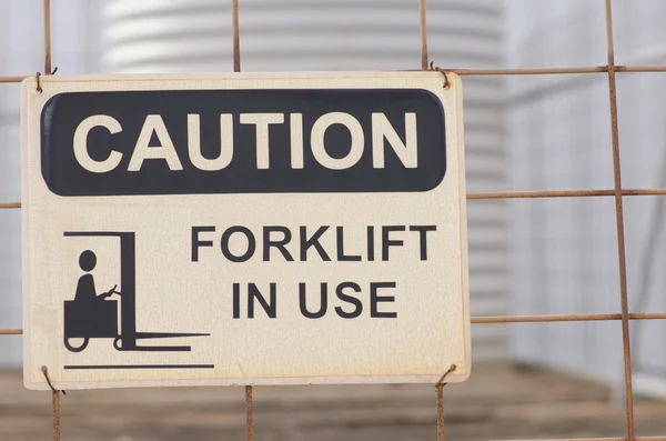 Safety sign at fence of forklift in use